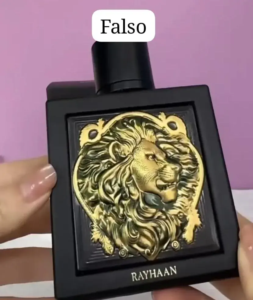 Frasco Rayhaan con un león en relieve, dorado brillante y menos detalle, señalado como sospechoso